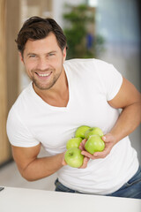 smiling man holding green apples