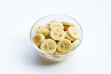 Banana slices in glass bowl on white