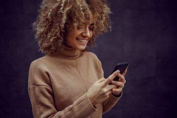 Smiling hip hop girl looking at cell phone and texting message to a friend. © Dusan Petkovic