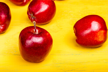Red apple on a yellow wooden table. Ripe apple. Farming.