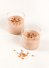 Creamy buckwheat pudding in a glass on a light background