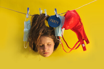 A conceptual  picture of a hanging teen's head on the rope with disposal masks over the yellow background symbolizing the craziness