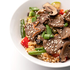 Close up of Rice with meat and sesame seeds. Food plate isolated on white background, Top view. Appetizer dish from restaraunt menu. Exquisite served dish. Soft focus.