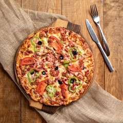 Meat pizza with bell pepper and tomatoes on wooden table. Delicious Pizza. Traditional italian food, top view. Nutrition dinner or lunch.