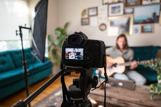 Video camera filming man playing guitar