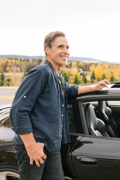 Man Standing Next To Sports Car In Countryside