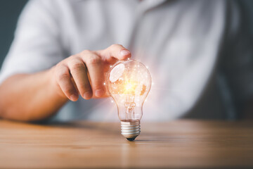 Businessman touching a bright light bulb. Concept of Ideas for presenting new ideas Great inspiration and innovation new beginning.