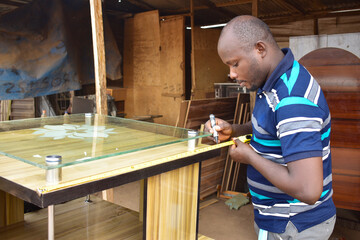 Black African carpenter working with carpentry  equipment in a  carpenter's workshop
