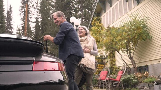 Slow Motion Of Couple Packing Car Outside Vacation Rental