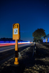 Emergency pillar at night on a german freeway while blue light is running in the background.