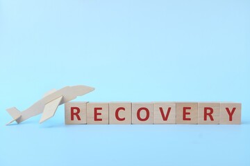 Airplane wooden model on blue background. Reopening and recovery of travel, airline and aviation...