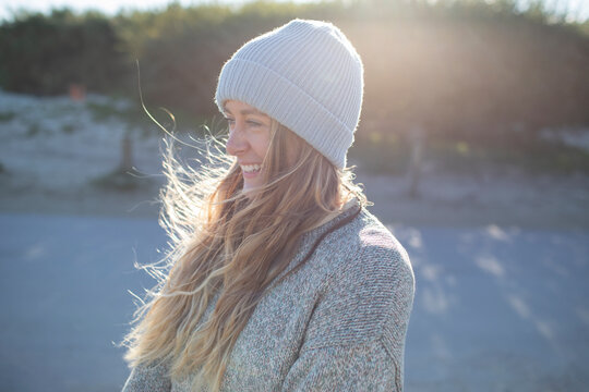 Beautiful Happy Young Woman In Knit Hat On Sunny Beach