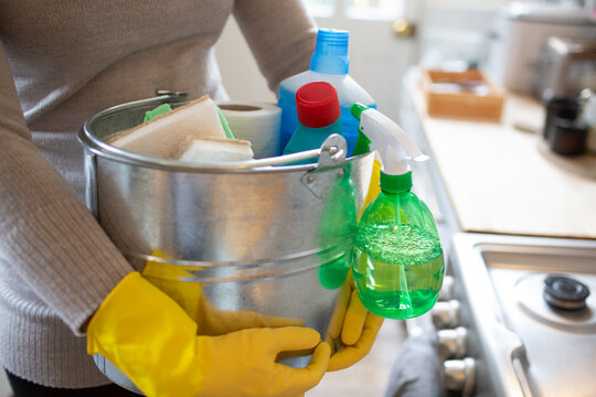Close up woman in rubber gloves with cleaning supplies