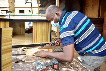 Black African carpenter working with carpentry  equipment in a  carpenter's workshop
