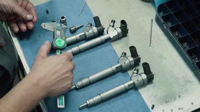 Engine injector repair. Male mechanical measuring elements nozzle caliper. Close-up.
