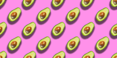 Seamless pattern of fresh ripe green avocado isolated on pink background. Top view. Banner. Flat lay composition. Pop art design. Creative summer food background
