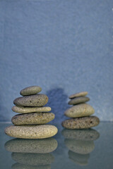 Two gray stone river towers for spa with blue background on glass