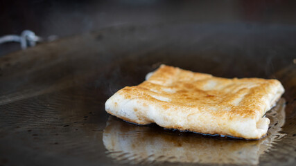 Making Roti with Oil Traditional indian street food Thai Banana Egg Pancakes. Street food and Thai desserts Making Roti on the Pan for Snacks