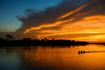 A boat during sunset on the Guaporé-Itenez river, Guaporé River Indigenous Land, Rondônia state, Brazil - Bolivia border