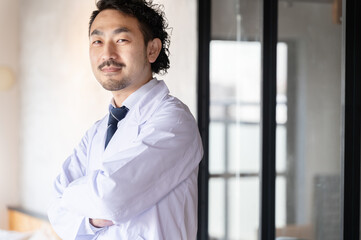Fototapeta premium 笑顔が似合うアジアの日本人男性ドクター コピースペースあり
