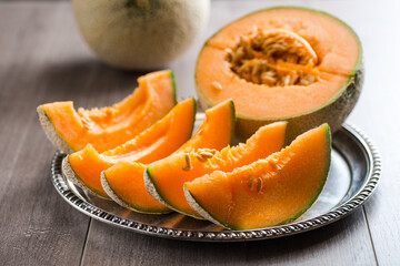 ripe melon cut into pieces on a platter