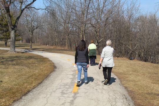 Three Older Women  Walking On A Trail At The Skokie Northshore Sculpture Park In Skokie, Illinois