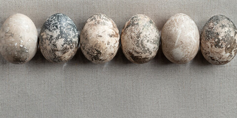 Easter composition - several painted with natural dyes with marble effect on a linen tablecloth in a row