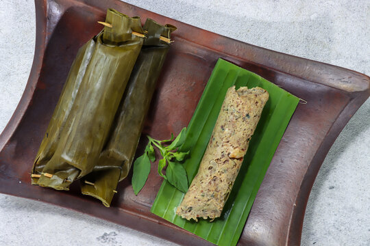 Pepes besusul or tutut is indonesian cuisine, made from fresh water slug or snail and coconut grated with a mixture of Chinese petai wrapped in banana leaves and steamed.