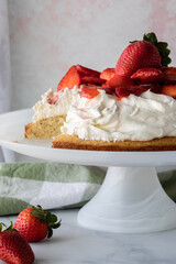 Close up of a strawberry shortcake with one slice cut out.