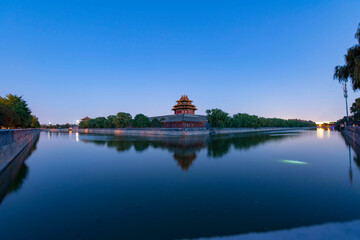 corner building of forbidden city with reflection