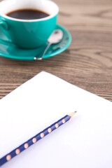 A cup of coffee and writing instruments