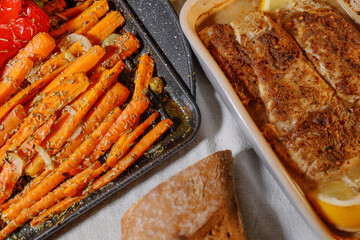 Oven-baked codfish with lemon and marinade. and oven roasted carrots with rosemary, and bread.