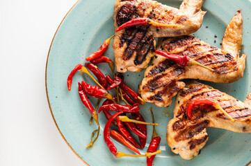 grilled chicken wings on a plate, restaurant serving, close-up top view