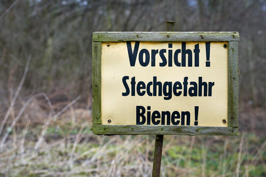 Schild am Waldrand mit der Aufschrift Vorsicht Stechgefahr Bienen