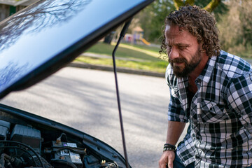 車の故障修理点検をする白人男性