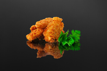 Chicken fillet nuggets. Close-up. Isolated. Dark background. Reflection