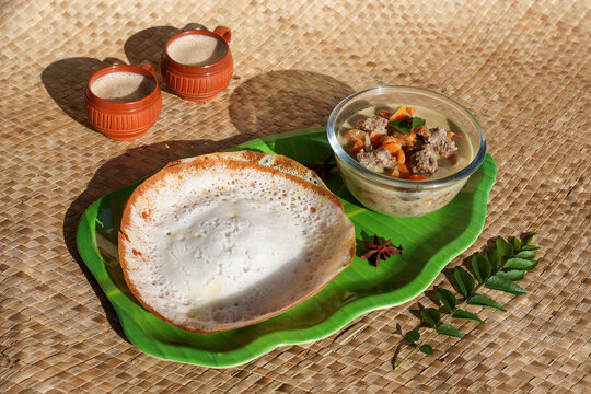 Appam, Hoppers and mutton stew Kerala breakfast food and Indian milk tea chai, christian breakfast India Sri Lanka Tamil Nadu fermented rice pan cake. Indian veg food.