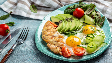 Healthy breakfast. Chicken grilled fillet with salad fresh tomatoes, cucumbers, eggs and avocado. Keto Paleo diet menu. top view