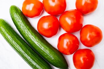 Tomatoes and cucumbers lie on the table close-up