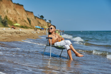 Happy boy is resting on the sea coast