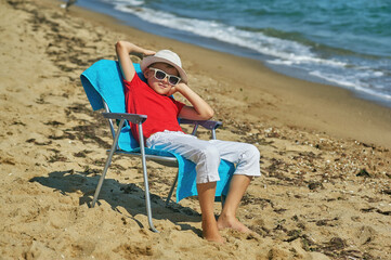 Happy boy is resting on the sea coast
