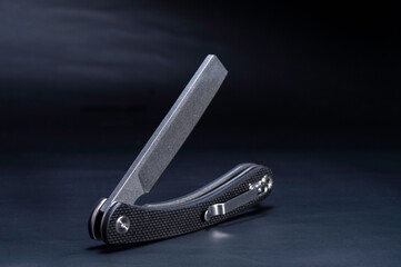 Knife with a clip on the handle. The knife is in an unusual position. Pocket knife with clip.