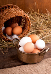 Chicken eggs in basket on wooden background