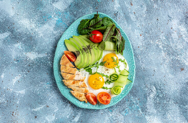 Ketogenic Diet Food, healthy meal. Homemade keto Chicken grilled fillet with salad fresh tomatoes, cucumbers, eggs and avocado. top view