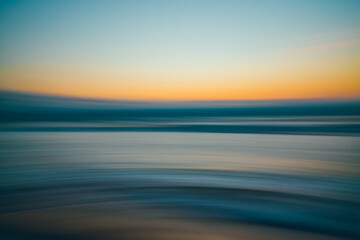 Fototapeta premium Golden hour on the beach, abstract seascape background, line art, soft blur, water surface, yellow, blue, turquoise colors