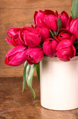 Fresh pink tulips on the wooden background.