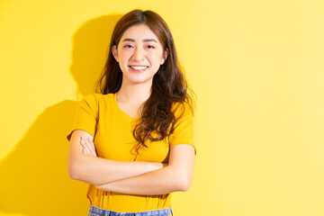 Young Asian girl posing on yellow background