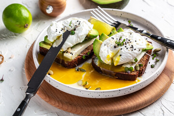 Sandwich with avocado and Poached Egg. Wholemeal Bread Toast sliced avocado and egg with cup of coffee for healthy breakfast or snack