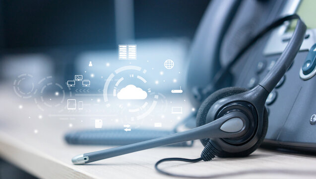 close up soft focus on headset with telephone devices at office desk for customer service support with communication icon technology concept