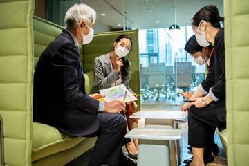 Naklejka premium 会社のスペースで気楽にミーティングを行っている社員たち